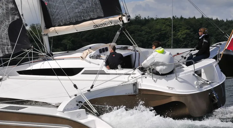 Slide: The Image of Sailing on a Dragonfly 32 trimaran, 2026 model, with crew navigating through water. - 9