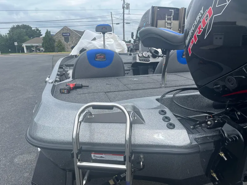 Slide: The Image of 2025 Ranger Z185 boat with Mercury Pro motor and ladder on a parking lot. - 2