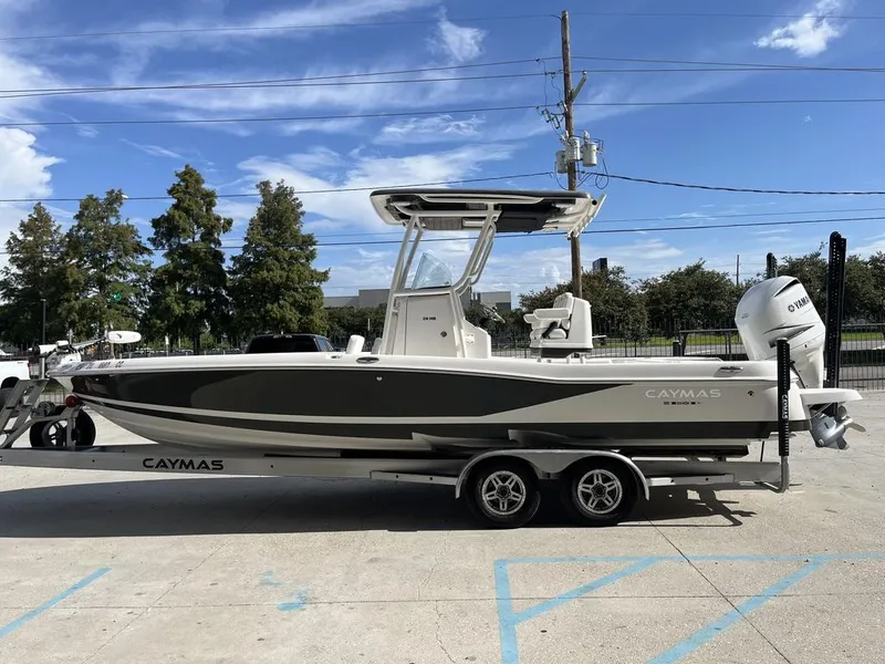 Slide: The Image of 2021 Caymas 26 HB boat on trailer, parked outdoors under blue sky. - 11