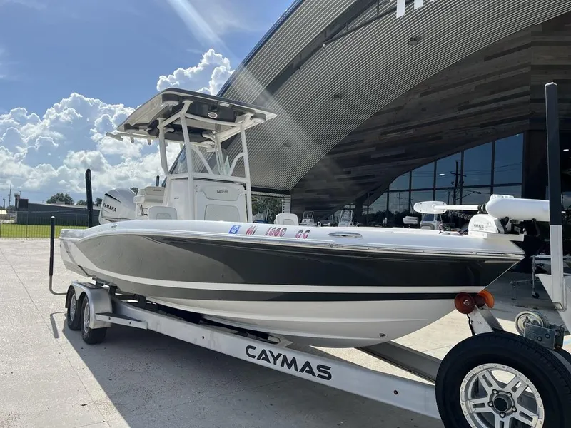Slide: The Image of 2021 Caymas 26 HB boat on trailer under sunny sky. - 12