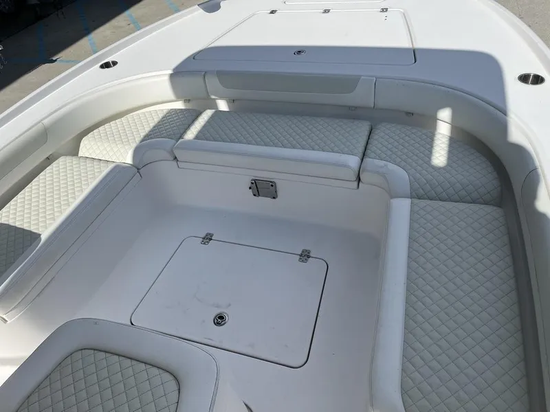 Slide: The Image of 2021 Caymas 26 HB boat interior with white quilted seating and storage compartment. - 16