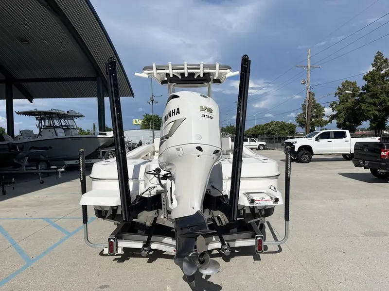 Slide: The Image of 2021 Caymas 26 HB boat with Yamaha V6 350 engine, parked outdoors. - 7