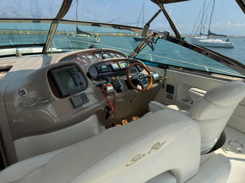 Slide: The Image of 2001 Sea Ray 380 Sundancer helm with leather seats and navigation equipment, docked in marina. - 10