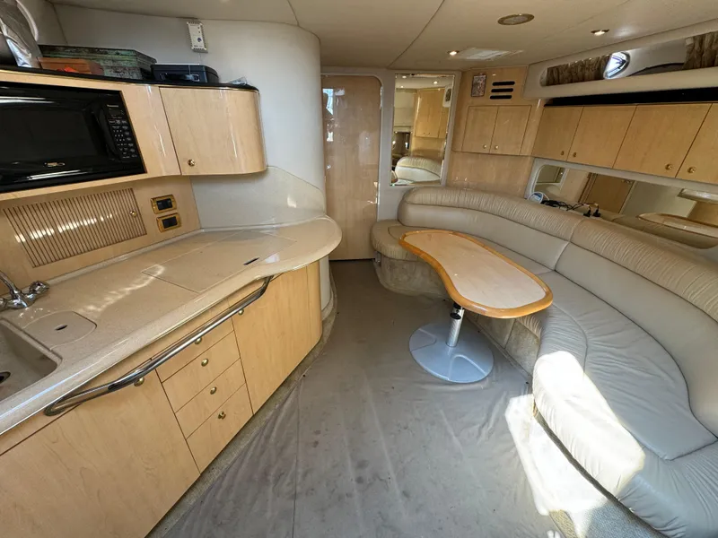 Slide: The Image of Interior of 2001 Sea Ray 380 Sundancer yacht with kitchenette and seating area. - 12