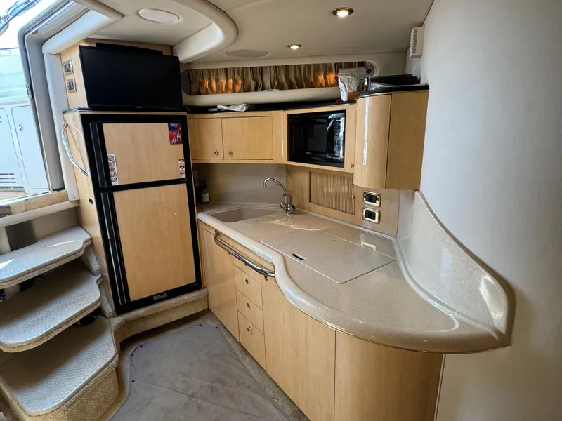 Slide: The Image of 2001 Sea Ray 380 Sundancer yacht kitchen with modern appliances and sleek cabinetry. - 14