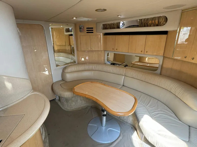 Slide: The Image of Interior of 2001 Sea Ray 380 Sundancer with beige seating and wooden cabinetry. - 16
