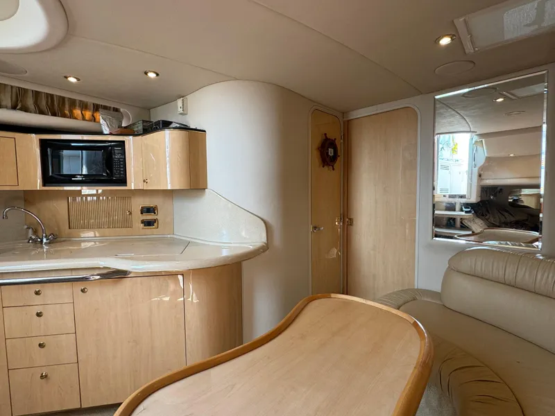 Slide: The Image of Interior of 2001 Sea Ray 380 Sundancer yacht with kitchenette and seating area. - 17