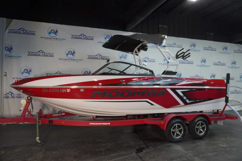 Slide: The Image of 2019 Moomba Craz boat in showroom, red and white design, on trailer. - 1