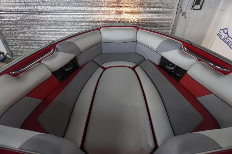 Slide: The Image of 2019 Moomba Craz MG boat interior with red and gray seating in a garage. - 17