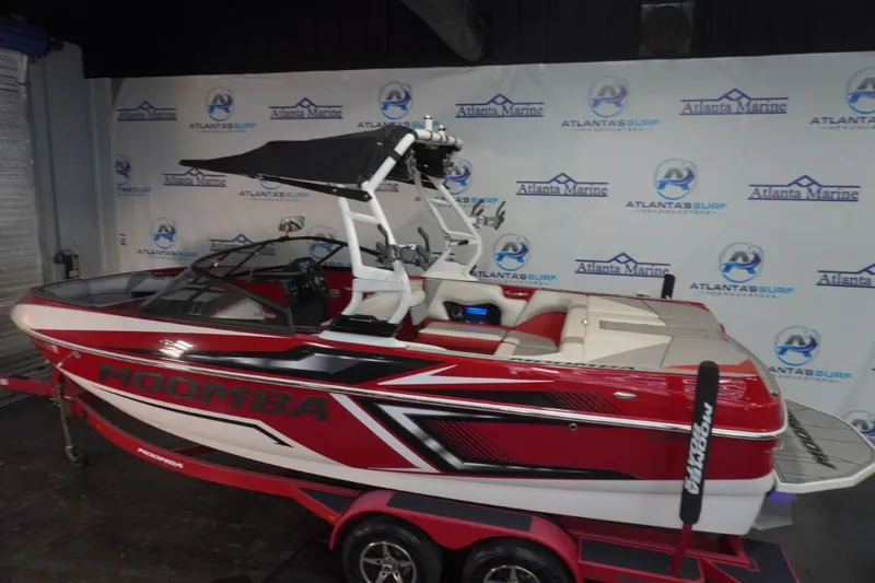 Slide: The Image of 2019 Moomba Craz MG boat in showroom, red and white design, on trailer. - 6