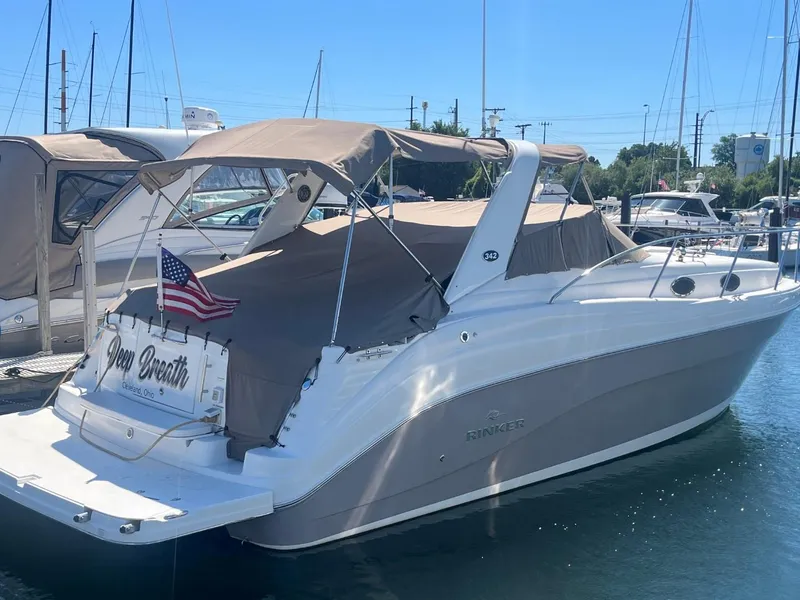 The Image of 2006 Rinker Fiesta Vee 342 boat docked with American flag, covered deck. - 0