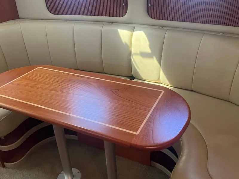 Slide: The Image of 2006 Rinker Fiesta Vee 342 interior with curved seating and wooden table. - 11