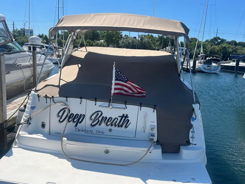 Slide: The Image of 2006 Rinker Fiesta Vee 342 boat docked, covered, with American flag. - 2