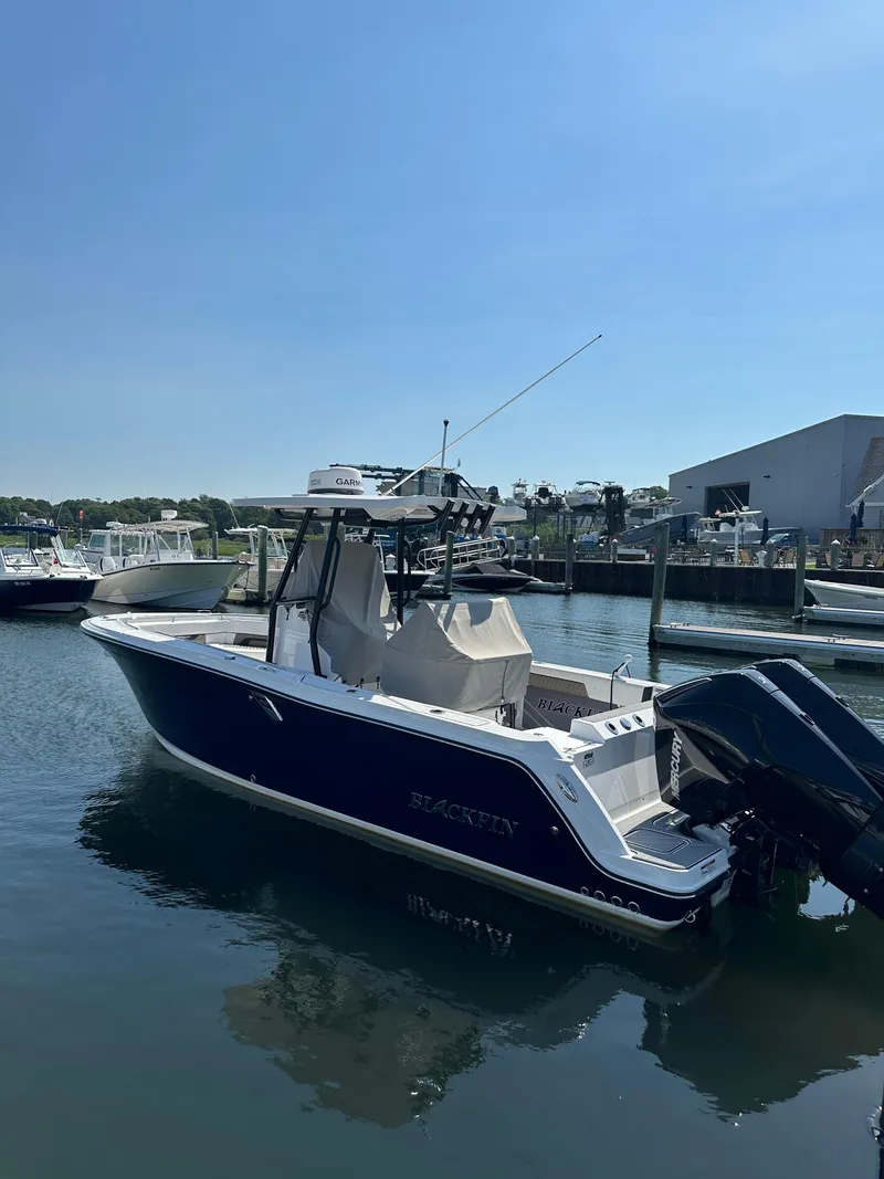 The Image of 2023 Blackfin 252CC boat docked in marina under clear blue sky. - 0