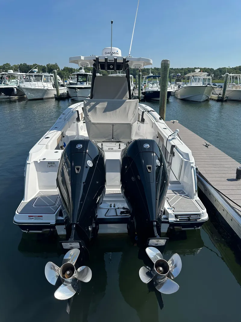 Slide: The Image of 2023 Blackfin 252CC boat with dual outboard engines docked at a marina. - 1
