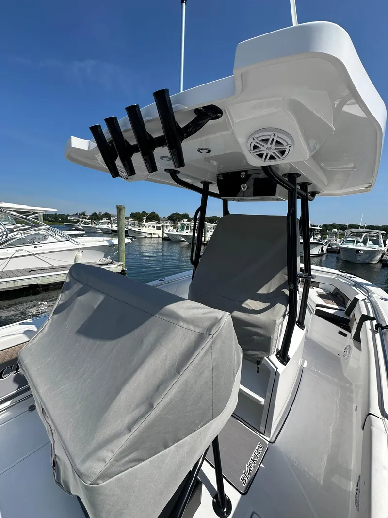 Slide: The Image of 2023 Blackfin 252CC boat with T-top and rod holders at marina. - 5