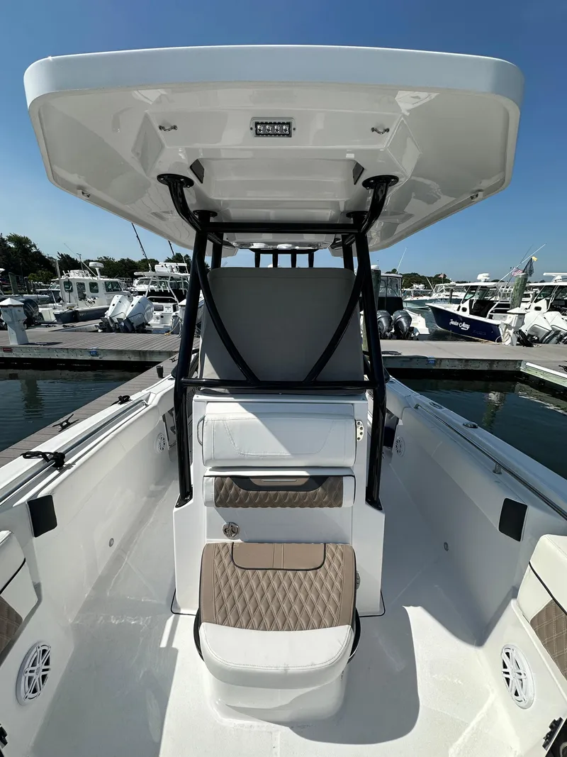Slide: The Image of 2023 Blackfin 252CC boat interior with seating and console, docked at marina. - 7