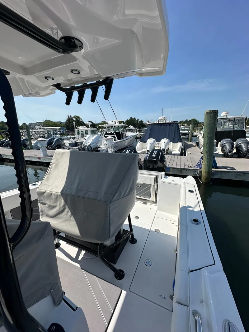Slide: The Image of 2023 Blackfin 252CC boat docked at marina, featuring covered seating and modern design. - 8