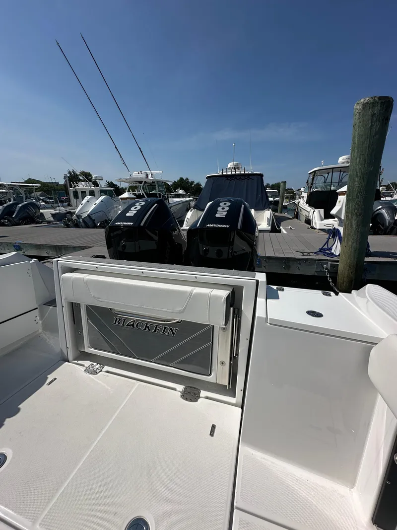 Slide: The Image of 2023 Blackfin 252CC boat docked with twin engines, clear sky background. - 9