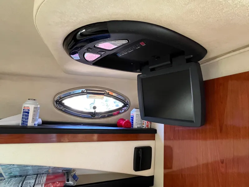 Slide: The Image of 2007 Sea Ray 270 Amberjack cabin interior with TV and porthole window. - 18