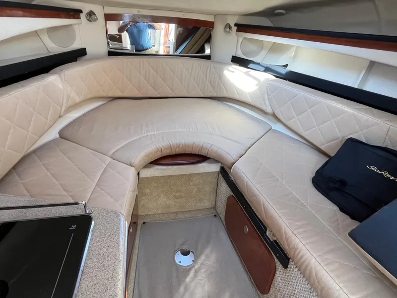 Slide: The Image of 2007 Sea Ray 270 Amberjack cabin interior with beige upholstery and storage compartments. - 19