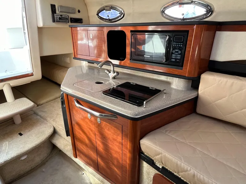 Slide: The Image of 2007 Sea Ray 270 Amberjack cabin with kitchenette, microwave, and seating area. - 20