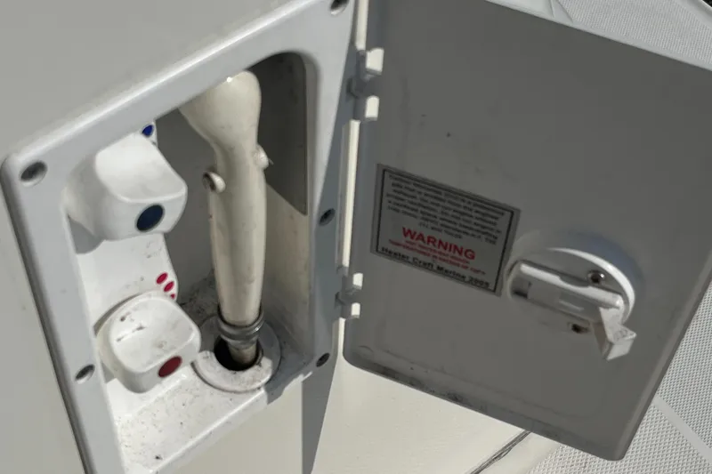 Slide: The Image of 2007 Sea Ray 270 Amberjack boat water hookup compartment with warning label. - 34