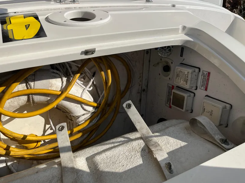 Slide: The Image of 2007 Sea Ray 270 Amberjack storage compartment with yellow hose and electrical panels. - 35