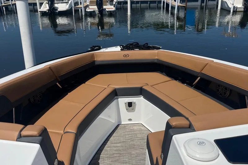 Slide: The Image of 2024 Cobalt R33 boat with tan seating, docked at a marina. - 13