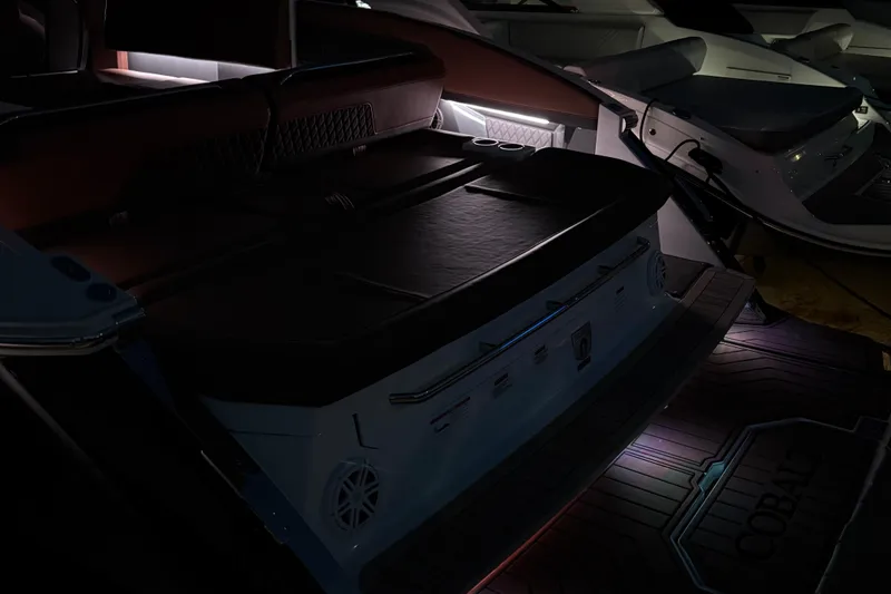 Slide: The Image of 2024 Cobalt R33 boat interior with ambient lighting and luxurious seating. - 17