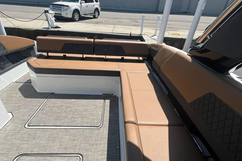 Slide: The Image of 2024 Cobalt R33 boat interior with brown seating and carpeted flooring. - 5