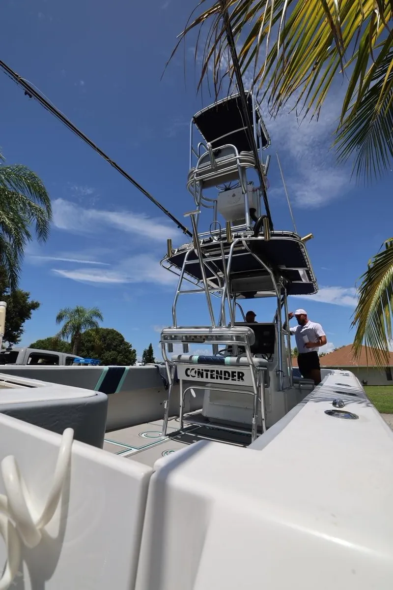 Slide: The Image of 2001 Contender 27 Open boat under palm trees with clear blue sky. - 11