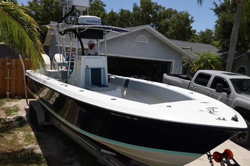 Slide: The Image of 2001 Contender 27 Open boat on trailer in driveway. - 15