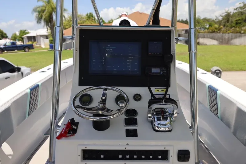 Slide: The Image of 2001 Contender 27 Open boat dashboard with steering wheel and electronic controls. - 22