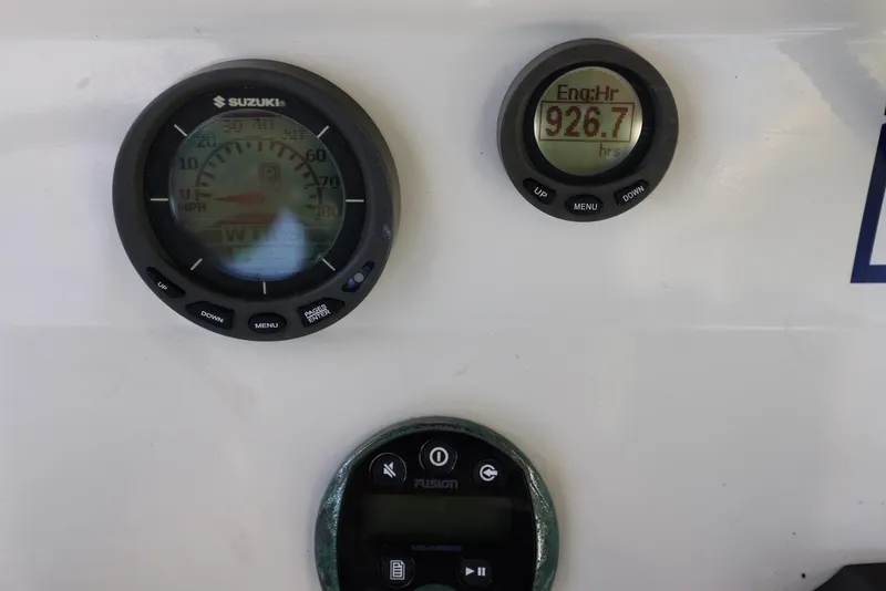 Slide: The Image of Suzuki engine gauges and Fusion audio control on 2001 Contender 27 Open boat. - 26