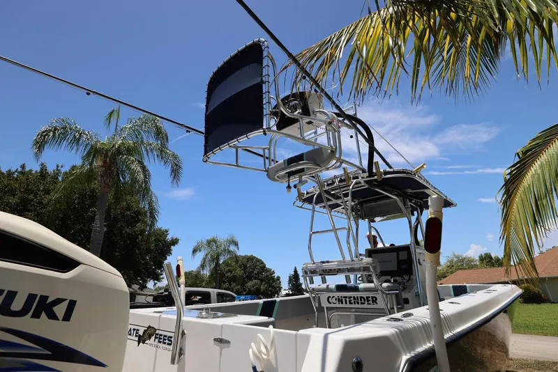 Slide: The Image of 2001 Contender 27 Open boat with Suzuki engine under palm trees. - 35