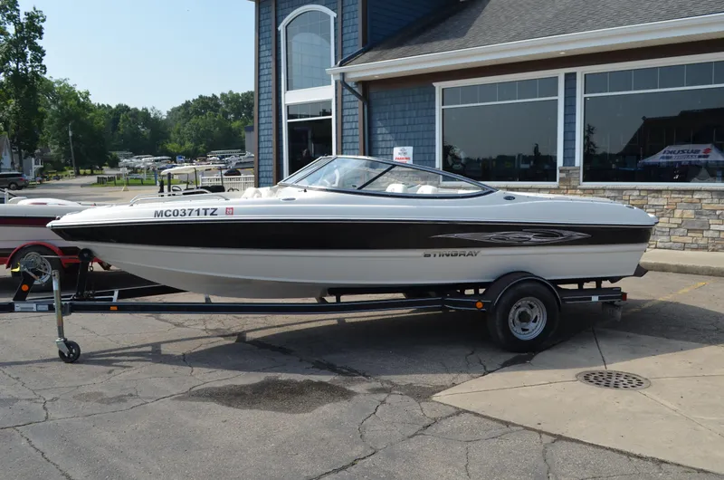 Slide: The Image of 2009 Stingray 205LX boat on trailer outside a building. - 0