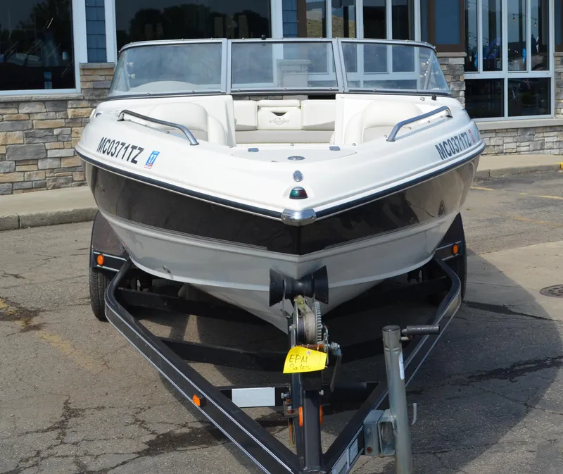 Slide: The Image of 2009 Stingray 205LX boat on trailer, parked outside a building. - 1