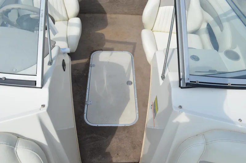 Slide: The Image of 2009 Stingray 205LX boat interior with white seating and glass windshields. - 6