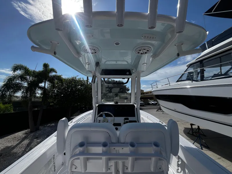 Slide: The Image of 2026 Sportsman Open 212 Center Console boat with T-top and dual seating, docked under clear sky. - 10