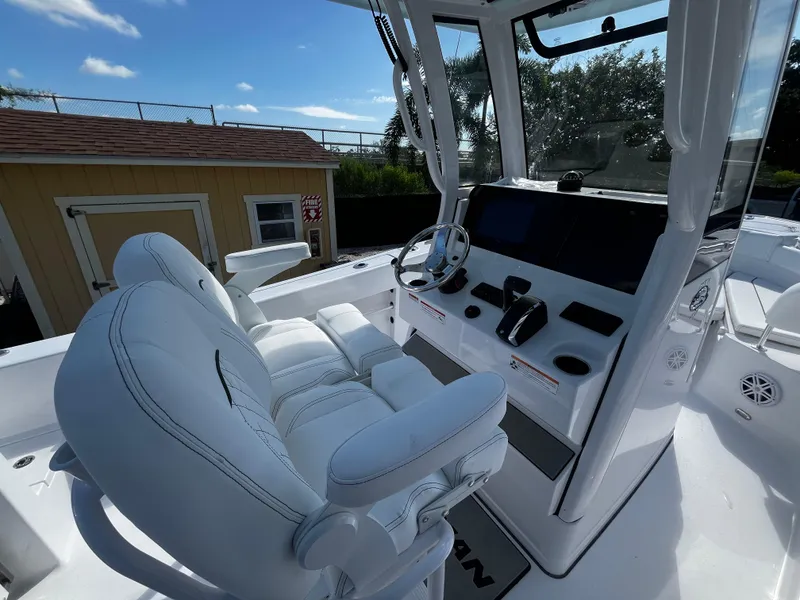 Slide: The Image of 2026 Sportsman Open 212 Center Console boat interior with white seating and modern dashboard. - 11