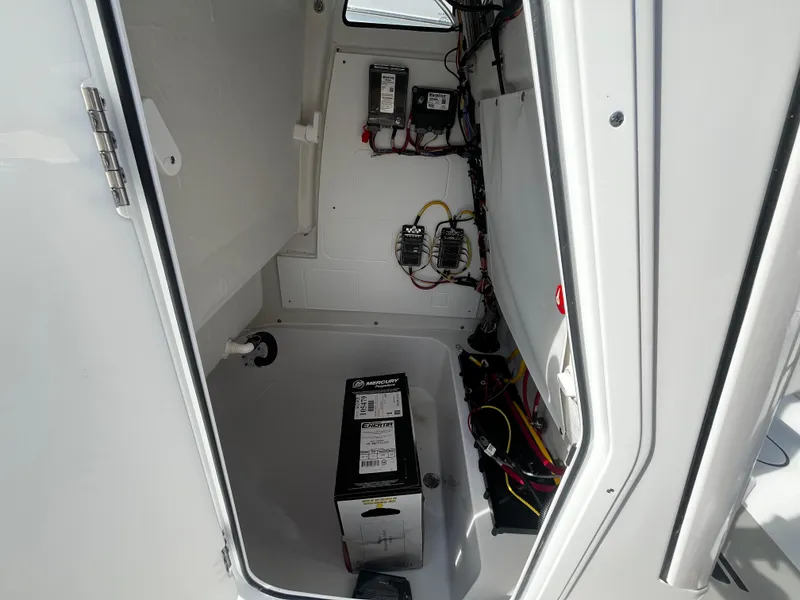 Slide: The Image of 2026 Sportsman Open 212 Center Console electrical compartment with battery and wiring. - 19