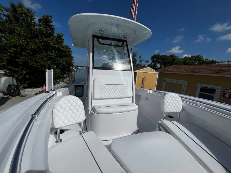 Slide: The Image of 2026 Sportsman Open 212 Center Console boat with white seating and clear skies. - 22
