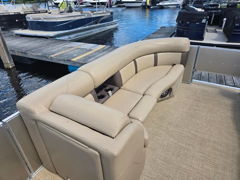 Slide: The Image of 2021 Harris Cruiser 230 boat with beige seating at a marina dock. - 6