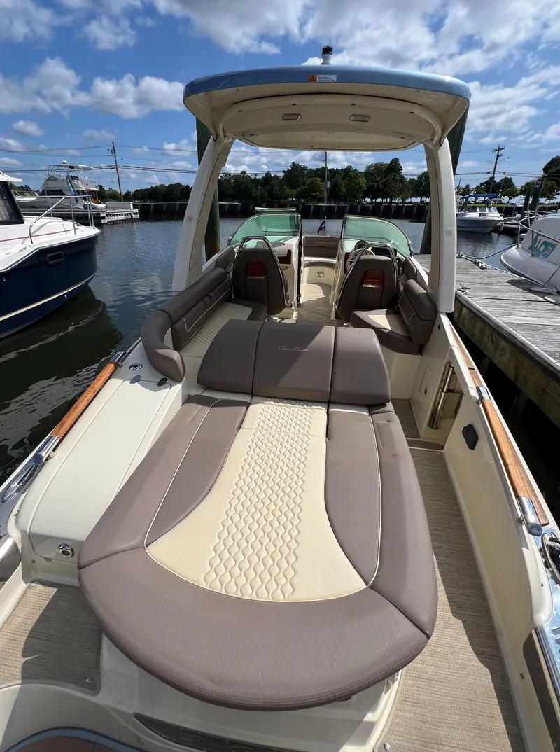Slide: The Image of 2023 Chris-Craft Launch 28 GT boat with luxurious seating and sleek design at a marina. - 10