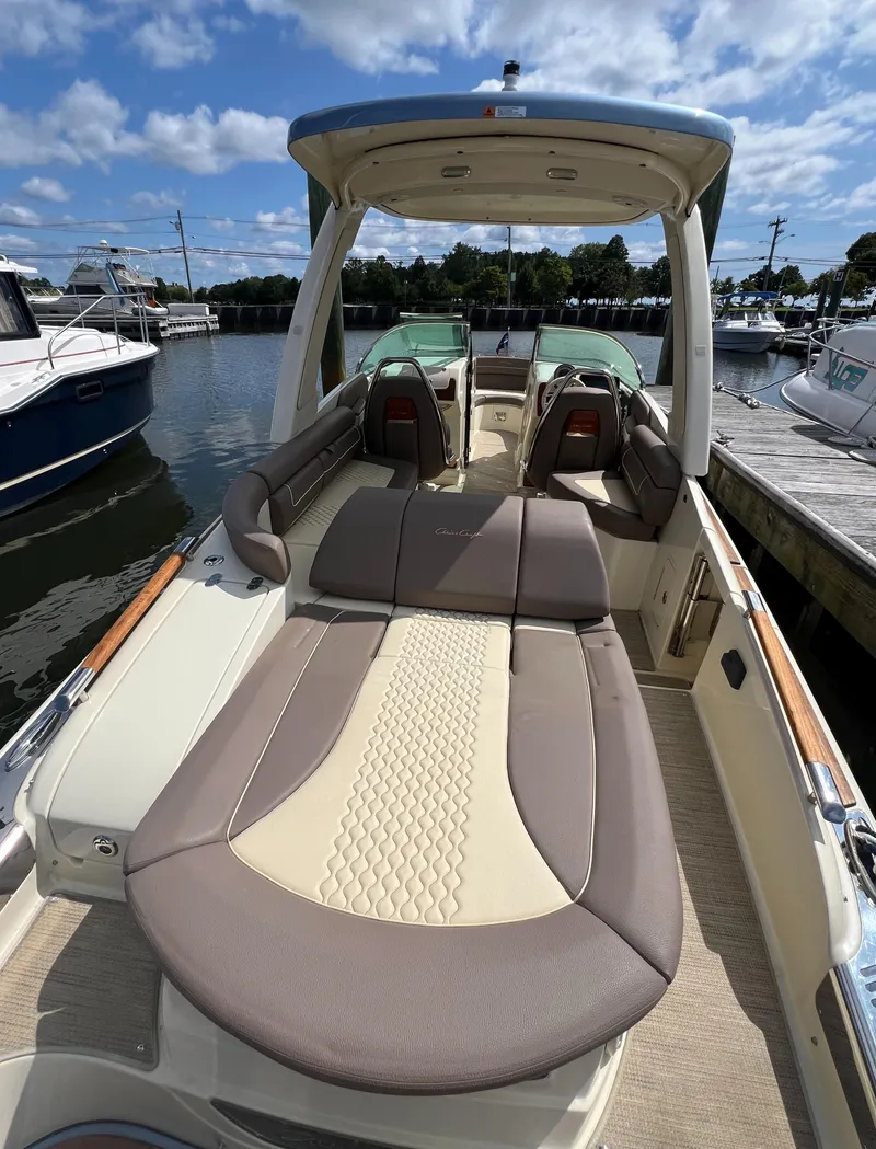 Slide: The Image of 2023 Chris-Craft Launch 28 GT boat with luxurious seating, docked at a marina. - 12
