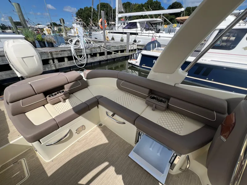 Slide: The Image of 2023 Chris-Craft Launch 28 GT luxury boat interior with plush seating at marina. - 15