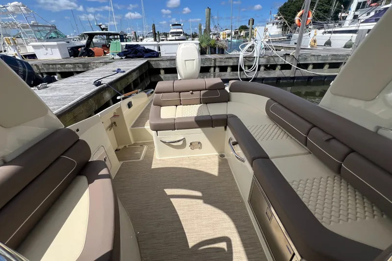 Slide: The Image of 2023 Chris-Craft Launch 28 GT interior with luxurious seating at marina. - 18