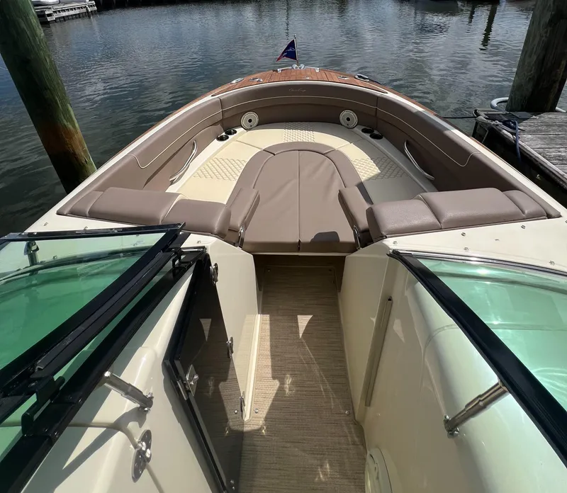 Slide: The Image of 2023 Chris-Craft Launch 28 GT boat interior with seating, docked on calm water. - 39
