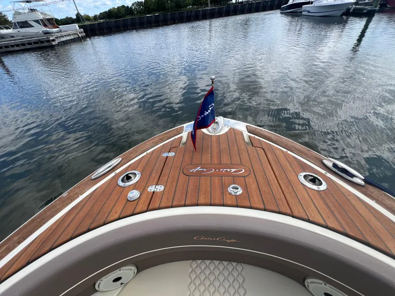 Slide: The Image of 2023 Chris-Craft Launch 28 GT boat with wooden deck, docked in a marina. - 47